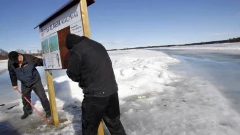 Åhej, åhå... Lars-Erik Lundström och Jörgen Stenvall lyfter med förenade krafter upp infotavlan som bedöms ha gjort sitt vid starten av Stadsfjärdens isbana.