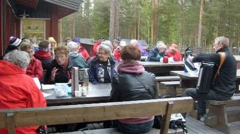 Trots gråmulet väder var stämningen på topp under SKPF-utflykten till Storforsen. För musikunderhållningen svarade Johnny Eriksson (till höger) från Älvsbyns dragspelsklubb.
