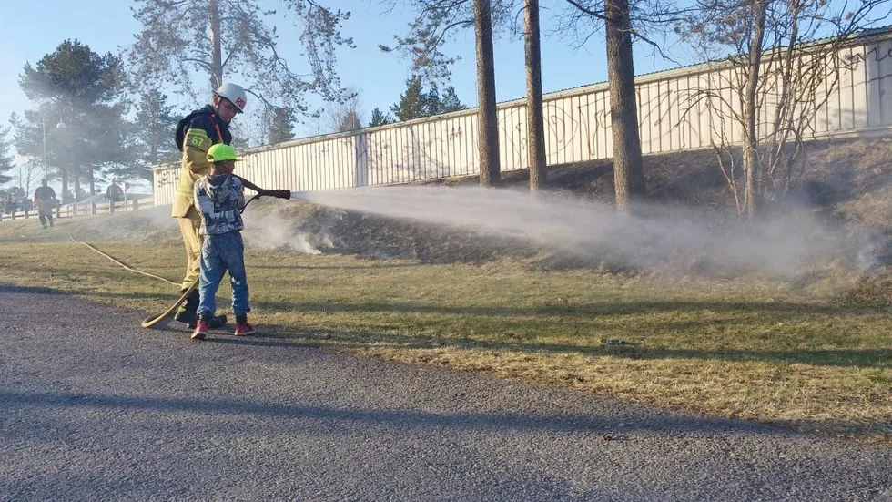Hjälpreda. En liten kille fick vara med och släcka en gräsbrand på Hertsön i Luleå på tisdagen. Foto: Pontus Johansson