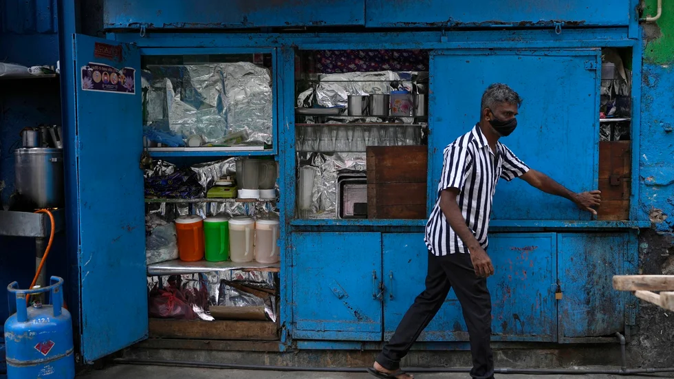 En man öppnar sitt gatukök i Colombo en morgon i oktober. Genrebild.