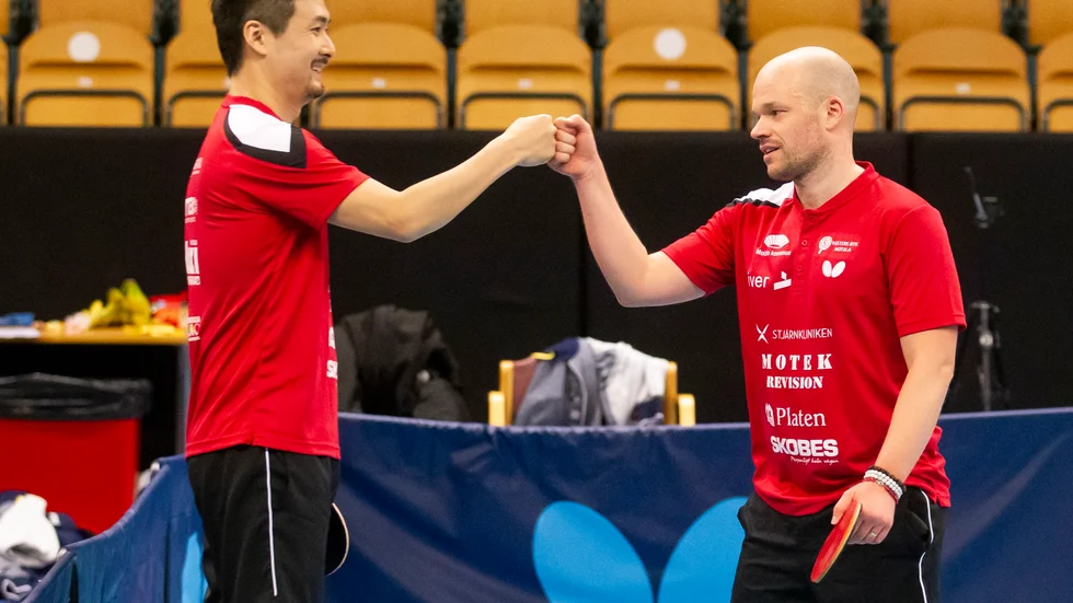 Jiang Changhong och Andreas Johansson firar efter att ha vunnit sin dubbel och därmed säkrat Västers BTK.s seger mot Eskilstuna. 