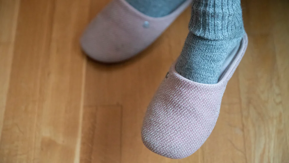 Tofflors hasande beröring mot golvet är en känsla av hemma.