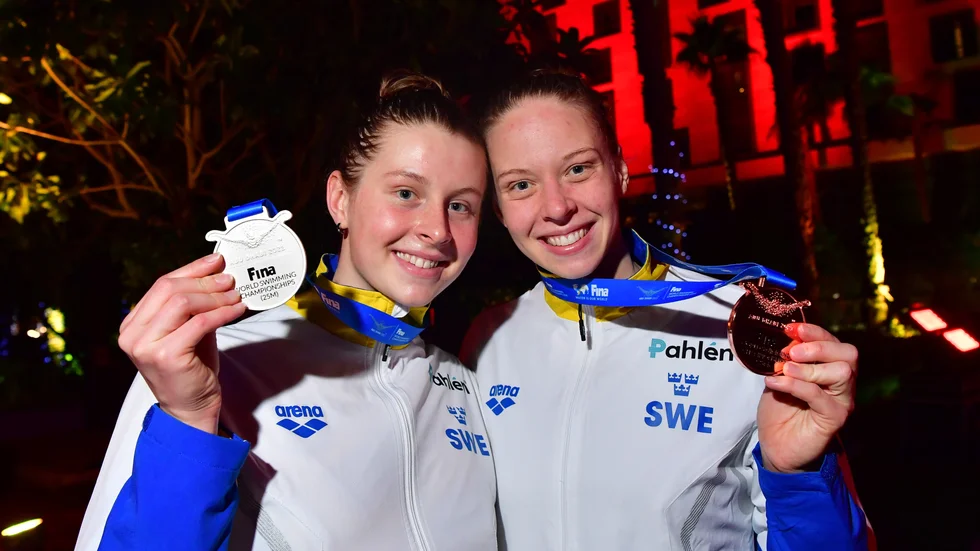 Sophie Hansson, till vänster, och systern Louise Hansson håller upp sina VM-medaljer.