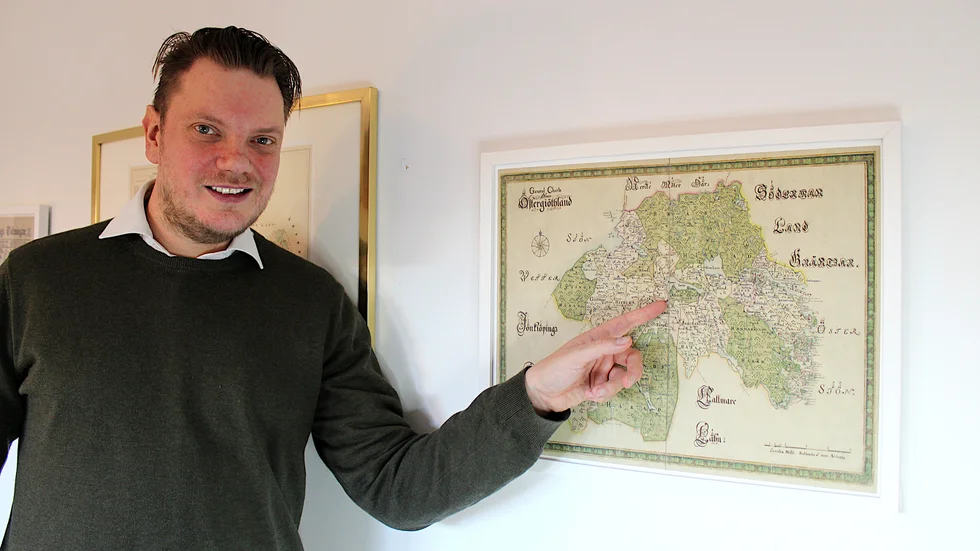 Lars Hindrum tar fram historiska kartor. Landskapskartan över Östergötland på väggen är från slutet av 1600-talet hör till favoriterna.  