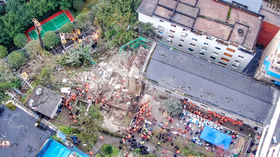 Räddningsarbetare vid rasmassorna efter explosionen.