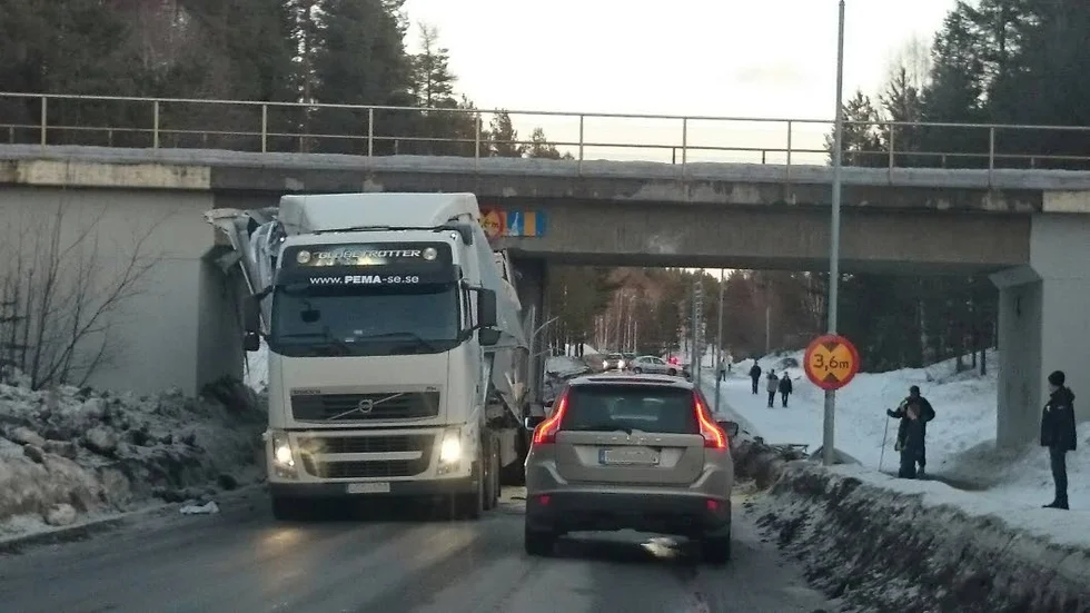 Fast. En lastbil med virke körde fast i en viadukt.