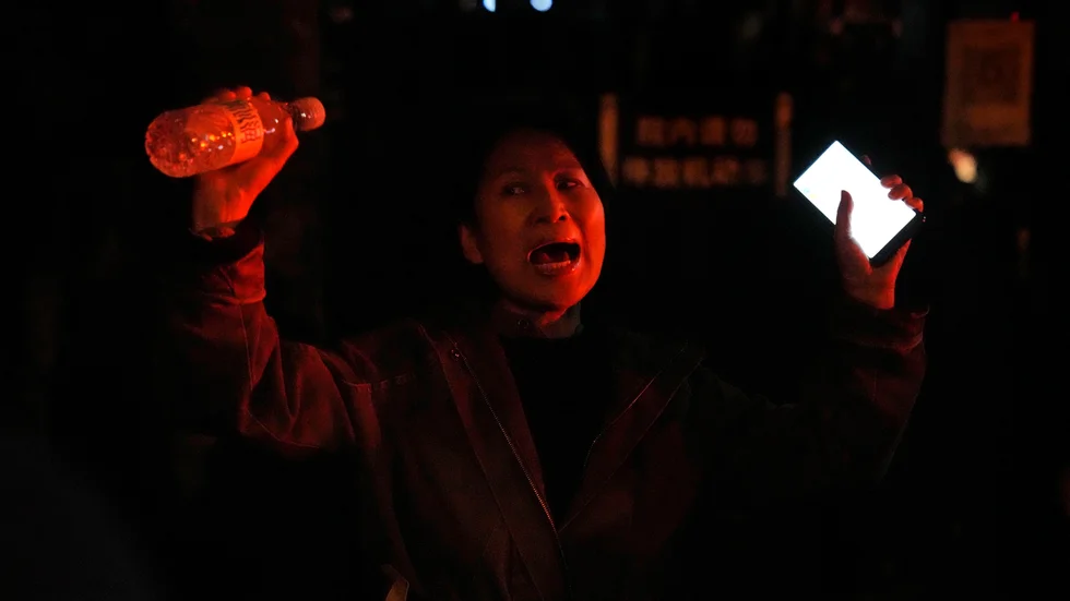 En kvinna protesterar i Peking mot regimens strikta "nollcovid"-politik.