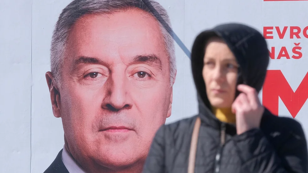En kvinna går framför en valaffisch med Montenegros sittande president Milo Dukanovic . Bild från den 16 mars.