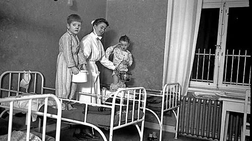En sjukhusbild från förr. Gossarna här verkar få hjälp med att använda fiffig bäckenvariant. Foto: Vimmerby kommuns bildarkiv