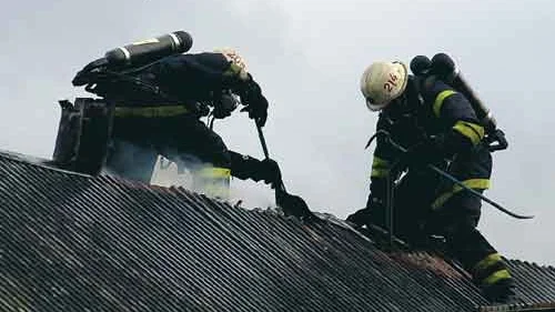 Brandmännen hade ett tufft jobb att bryta upp plåttaket på uthuset. Men det var nödvändigt för att komma åt brandhärdarna därunder. Blåsten gjorde det inte lättare att sitta på taket heller.