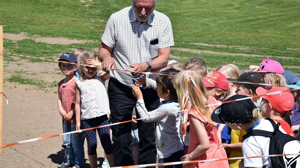 Kommunstyrelsens ordförande Hans Måhagen får hjälp av Enzo Tomé Beck-Friis med att klippa bandet. Foto: Morgan Karlsson