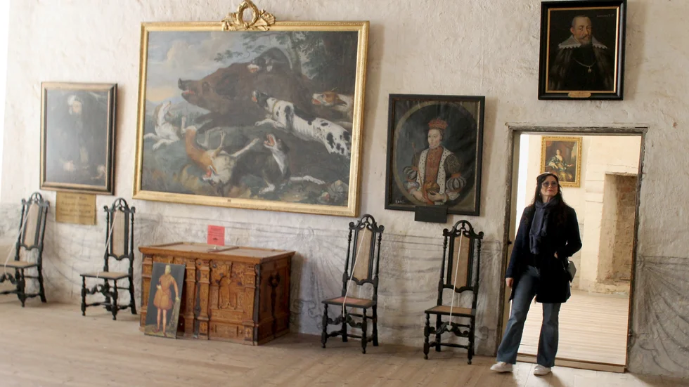 Vadstena slott är en välbekant miljö för guiden Karin Enåkander. "Det är så stimulerande, positivt och det gör mig så glad varje gång att få komma hit", säger hon om guidejobbet. När hon jobbar har hon på sig historiska kläder, här är hon i slottet på sin lediga dag.   