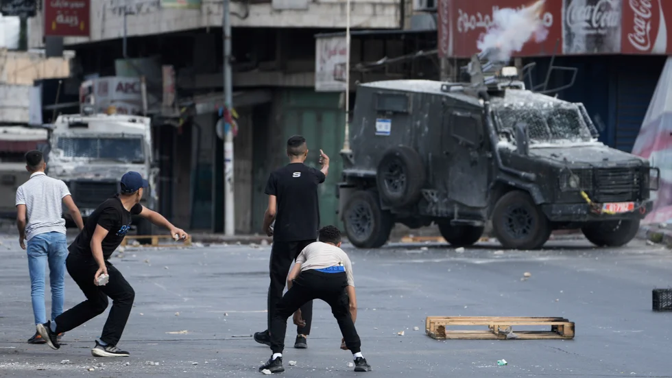 Palestinier i drabbning med israelisk militär i staden Nablus på Västbanken på fredagsmorgonen.