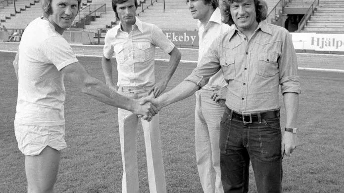 Välkommen! Siriusspelaren Ulf Wahlquist hälsar på Harry Kirk (t h) och hans landsman Frederick Hill (i bakgrunden t h). Med på bilden är även fotbollssektionens Dan Berglund. Bilden är tagen 21 juli 1975.