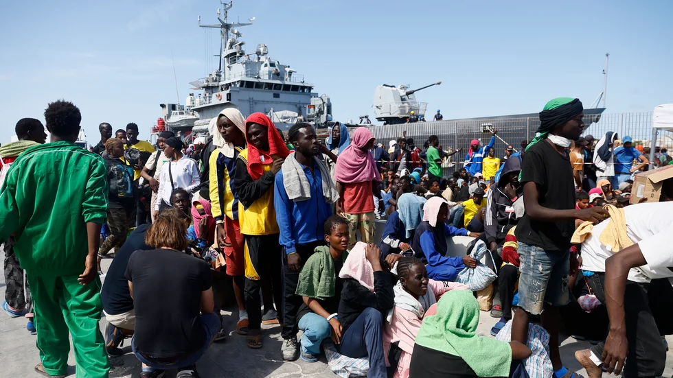 Migranter utanför Röda Korsets mottagningscenter på den italienska ön Lampedusa, en så kallad "hot spot" där ingen är tänkt att stanna mer än tre dygn.