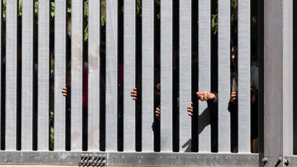 Migranter på andra sidan av den mur Polen byggt vid gränsen mot Belarus. Arkivbild.