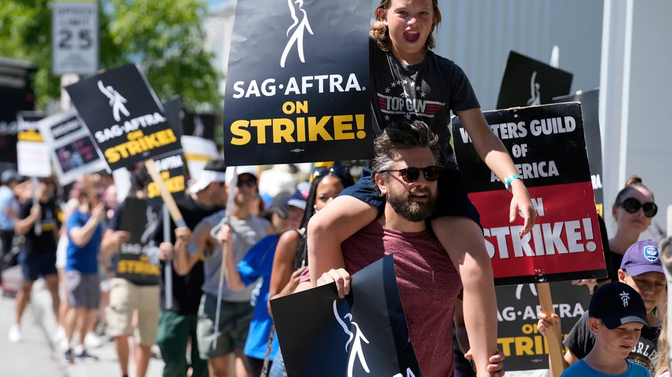 Den strejkande skådespelaren Jac Cheairs och hans elvaårige son Wyatte deltar i en demonstration utanför Netflix studio i Los Angeles förra veckan.