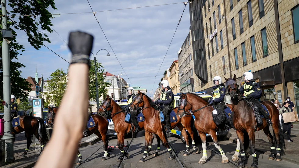 Knuten näve med svart handske framför ridande polis som skingrar demonstranter i samband med Black lives matter-demonstrationen i Göteborg. Polisen upplöste demonstrationen, men många av de 2|000 deltagarna tågade ändå vidare genom staden, och oroligheter uppstod bland på flera platser. Arkivbild.