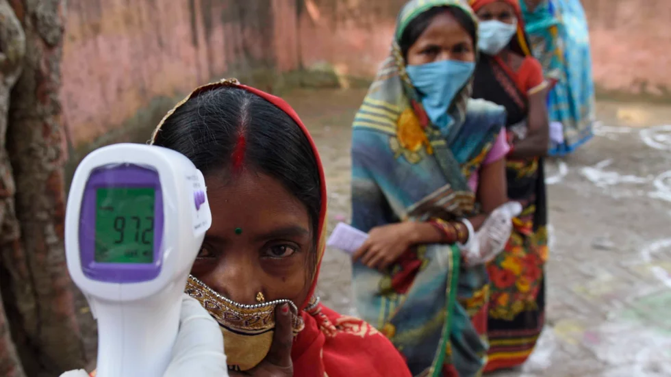 En kvinna får sin temperatur mätt under delstatsvalen i Bihar i östra Indien i slutet av oktober.