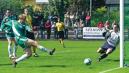 Hultsfreds Jonas Johansson testar ett skott mot Lasse Gustafson i Vimmerbys mål. Senare i matchen stötte samman igen och det slutade med ett rött kort för Johansson.