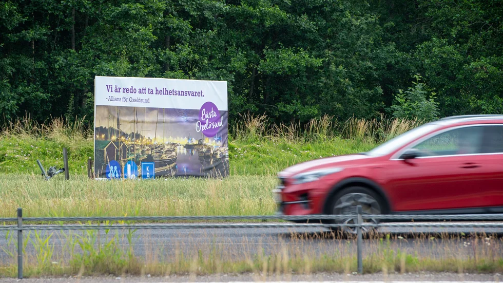 Affischen står längs med väg 53. Avsändare är Moderaterna, Liberalerna och Kristdemokraterna.