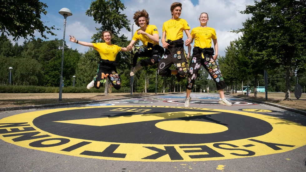 Faddrarna Maja Nilsson, Linus Laurell, Olle Unell och Amanda Sarfve hoppar på sitt programs märke på märkesbacken på campus.