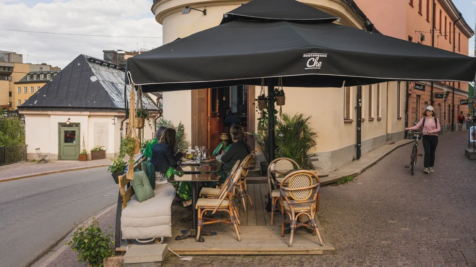 Restaurang Che i Uppsala med sin uteservering, där folk passerar på båda sidorna, vilket ger en trevligt myllrande stadskänsla.