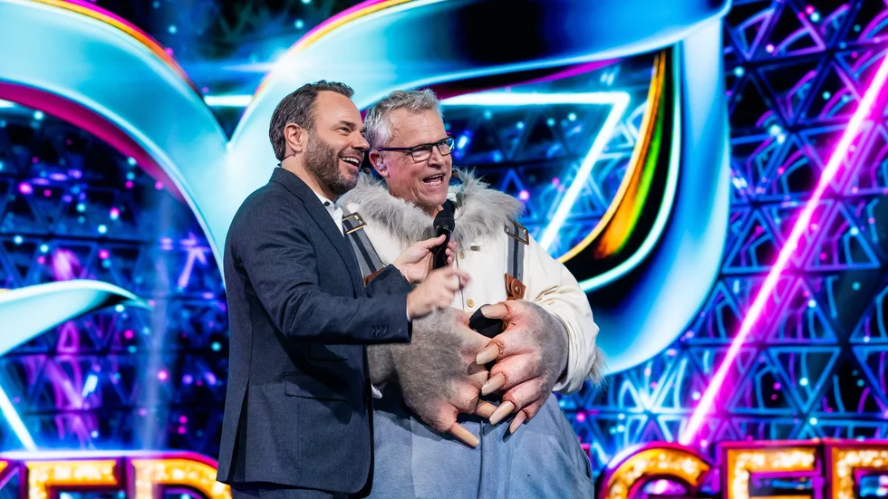 Programledaren David Hellenius avslöjar att det är Janne Andersson som är Mullvaden i "Masked singer". Pressbild.