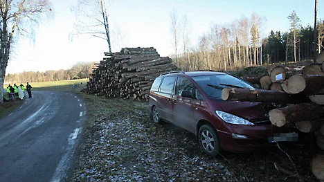 Bilen körde av vägen och vidare in i timmerhögen.