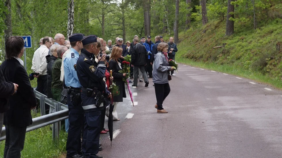 Poliser och anhöriga samlades vid minnesstenarna. Astrid Gladh, Robert Karlströms mor,  är på väg för att lägga blommor där.Foto: Pelles Photo/kisa