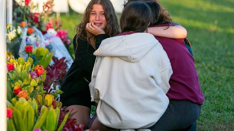 Sörjande vid en minnesplats vid gymnasieskolan Marjory Stoneman Douglas i Parkland i USA. Arkivbild.