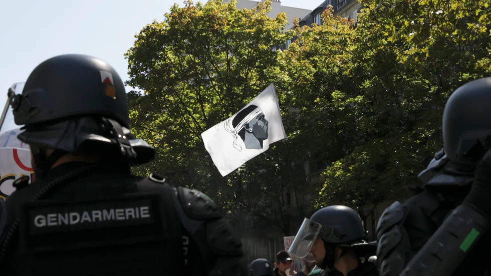 En demonstrant viftar med en korsikansk flagga vid en demonstration i Paris förra sommaren.