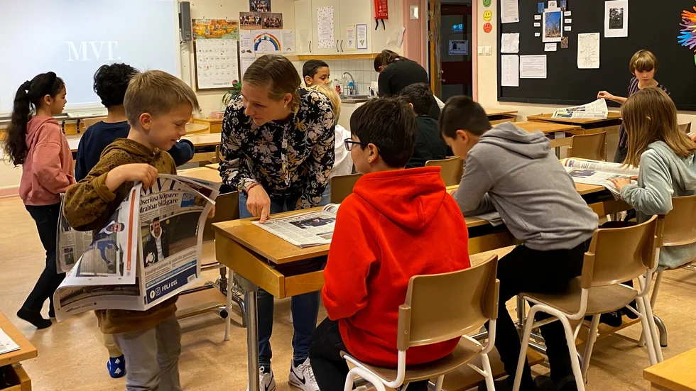 Emma Grenestam undervisar i klass 3c på Norra skolan i Motala. Bredvid henne står Simon Törnqvist, George Mardo sitter vid sin bänk.