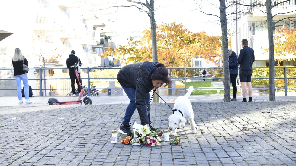 En person tänder ett ljus i närheten av platsen där artisten Einár sköts till döds i Hammarby sjöstad. Polis och ambulanspersonal larmades till Hammarby sjöstad i södra Stockholm på torsdagen, strax före klockan 23.