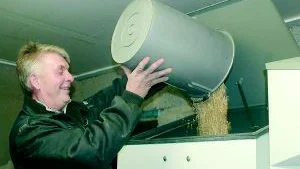 Fyller. Lennart Larsson fyller på spannmål, vilket man använder vid Hellerö gård som uppvärmning i tre fastigheter.