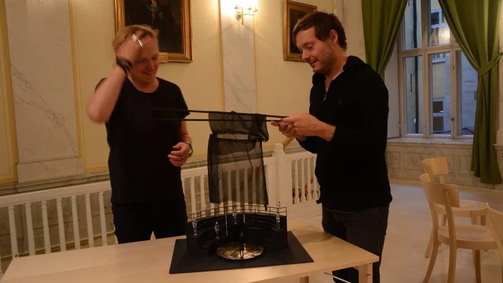 Amfiteater. Linus Fellbom, senografi/ljus till vänster i bild. Till höger ses operans regissör Kristofer Steen vid en miniatyrmodell över operans scenografi.