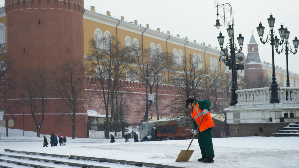 En man skottar snö utanför Kreml i centrala Moskva.