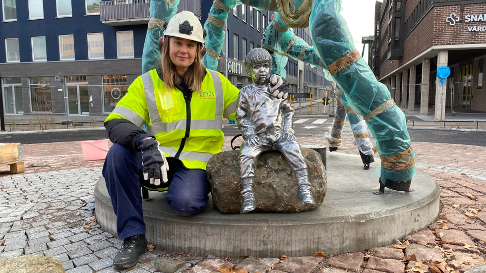 Elin Magnusson poserar tillsammans med sitt konstverk i rondellen på Tullgatan.