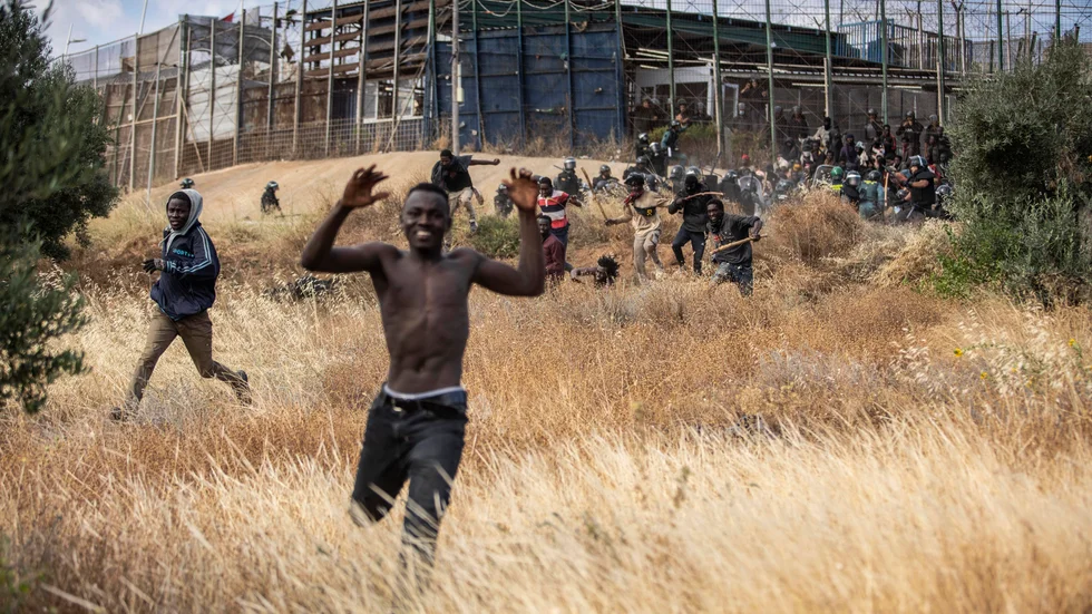 En man springer efter att ha korsat stängslet som skiljer Marocko och den spanska exklaven Melilla åt i juni.