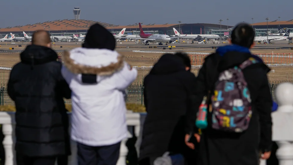 Resandet inför den kinesiska nyårshelgen väntas öka smittspridningen i landet. Bilden är tagen vid flygplatsen i huvudstaden Peking på söndagen.