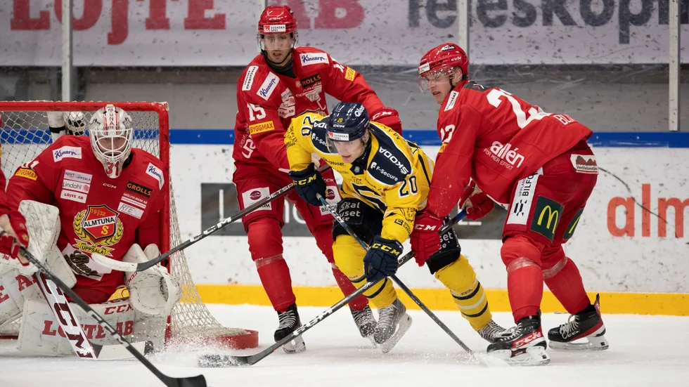 Marcus Karlström (röd tröja i mitten) jobbar för att få bort pucken framför målvakten Viktor Andrén. Almtuna vände och vann matchen mot Södertälje och lyfter iu tabellen.
