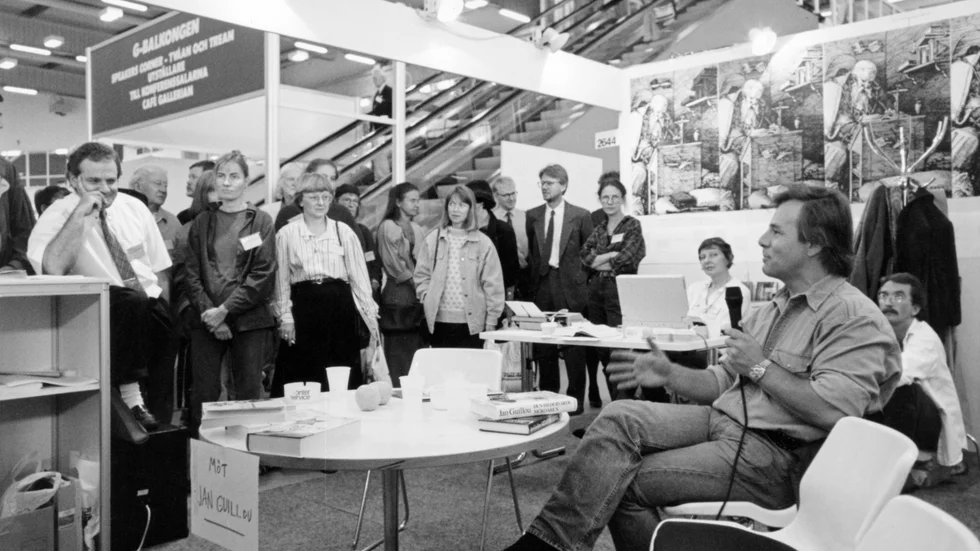 "Möt Jan Guillou", den svenske författaren och journalisten berättar om hur saker och ting "egentligen" ligger till under Bokmässan i Göteborg 1990. 