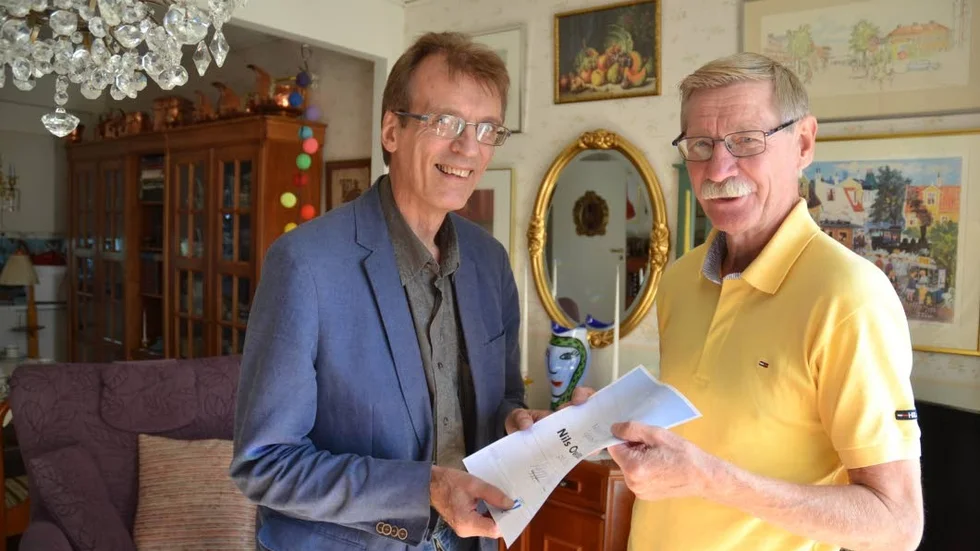 70-årsgrattis. Folkbladets Sören Boström gratulerar tidningens trotjänare Nilsove Magnusson på hans 70-årsdag.  I händerna håller Nilsove grattistelegrammet på födelsedagen från hans favoritlag Malmö FF.