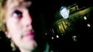 Olle Palmlöf vill få fram en gerillakänsla i sitt nya samhällsprogram, "Faktum". Ett led i det är att projicera en 15 meter hög bild av Bert Karlsson på Riksdagshuset i Stockholm till ett reportage om hårdare svensk flyktingpolitik.
FOTO: FREDRIK PERSSON/PRESSENS BILD