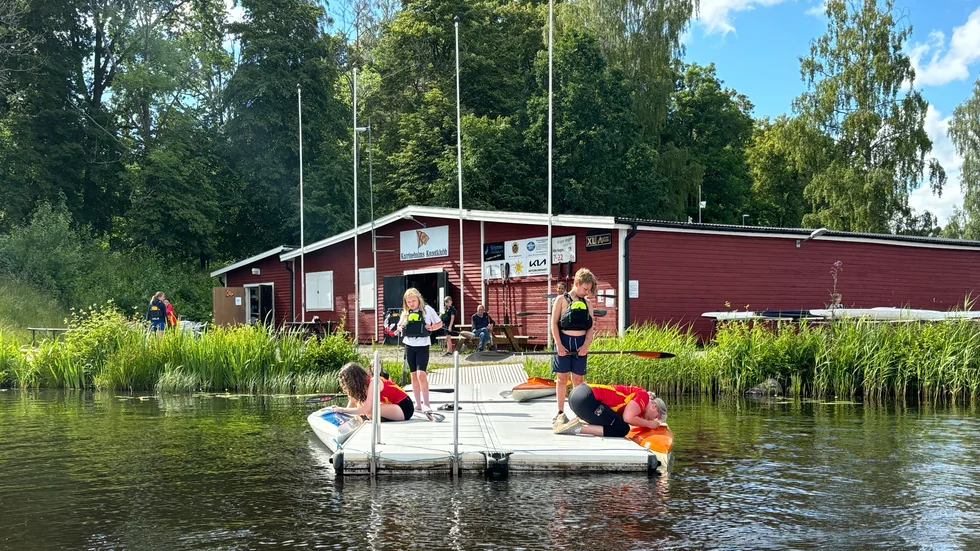 Ivriga barn får hjälp av kanotskolans ledare med att komma ner i kanoterna. 