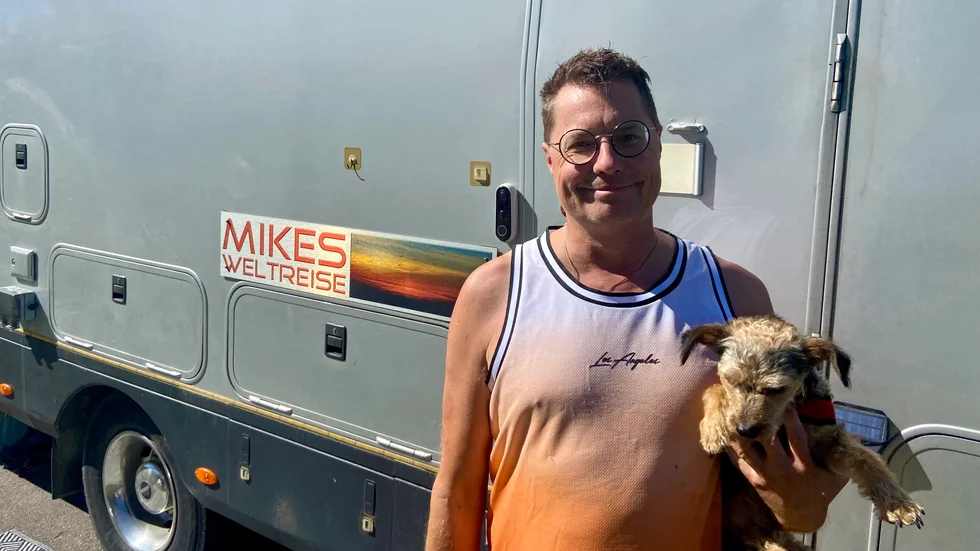 Tyske Mike sålde huset i Tyskland, lämnade livet som företagare och reser nu runt i Europa. Han gillar inte vanliga campingar och försöker hitta andra platser, som exempelvis parkeringen bakom isbrytarkajen.
