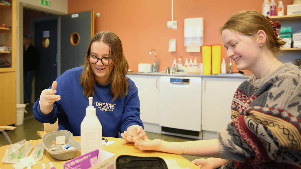 Omvårdnandsstudenten Wilma Karlsson tar ett "sockerprov" på klasskamraten Emma Johansson.