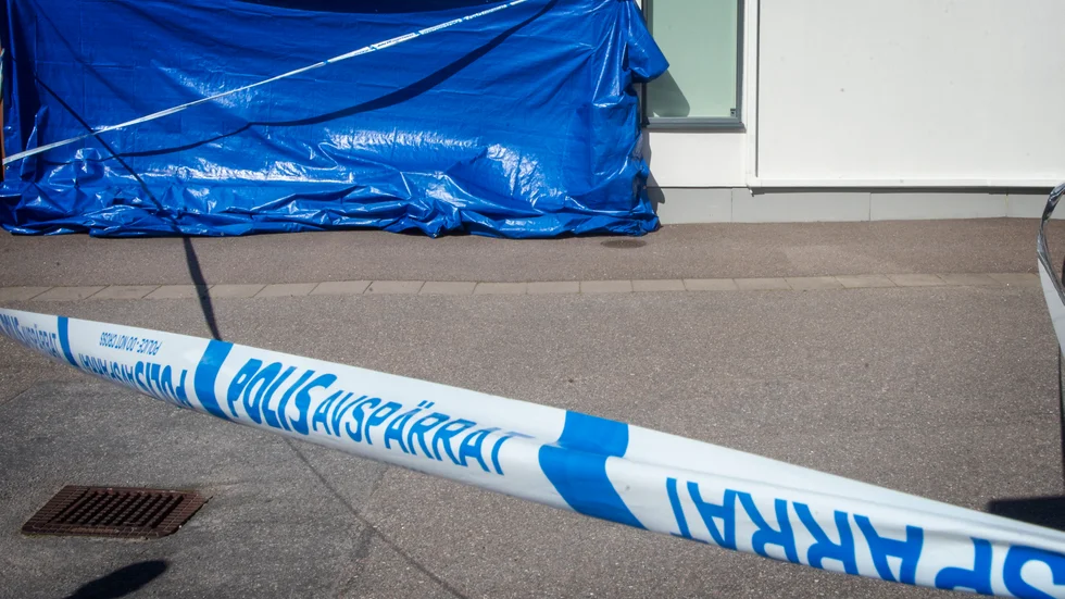 En blå presenning döljer de omfattande skador som bomben orsakade på radhuset i Högbrunn.