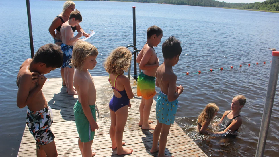 Simläraren Ebba Turesson tar emot barnen i vattnet vid bryggan på Kristinebergsbadet.