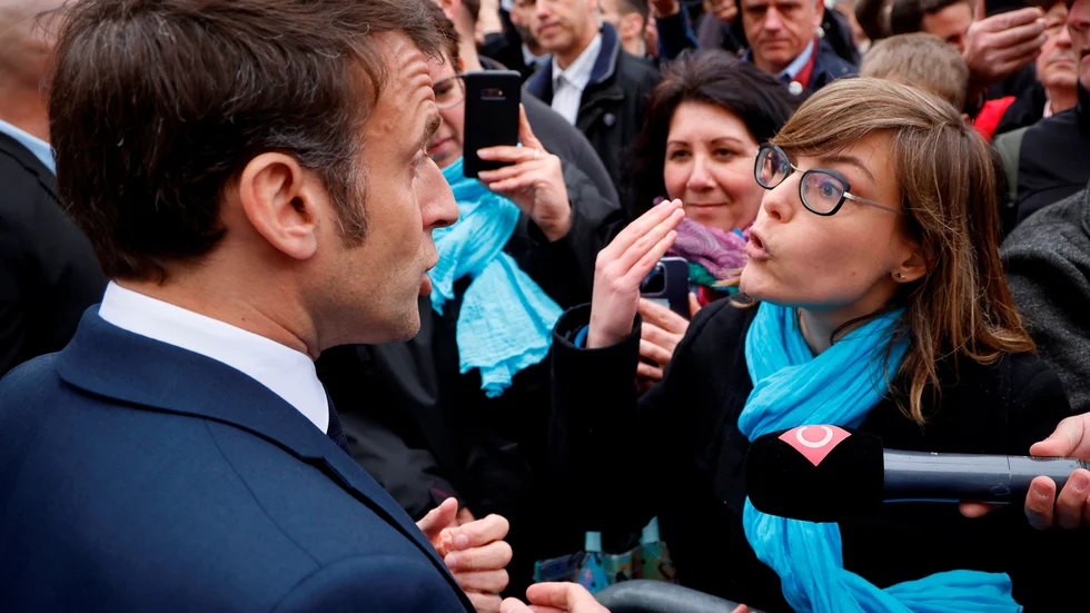 Frankrikes president Emmanuel Macron i hett samtal med en motståndare till de nya pensionslagarna.